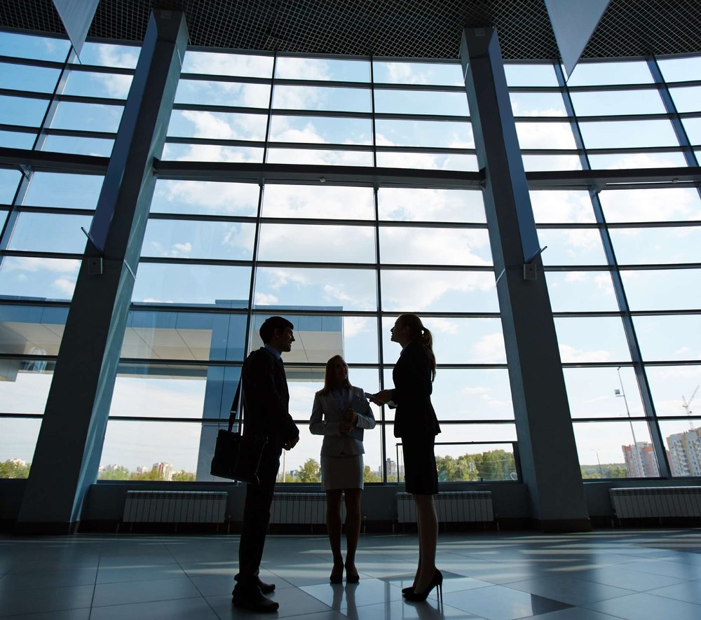 Colleagues meeting inside a glass office building